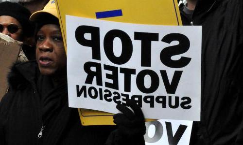 Woman holding 'Stop Voter Suppression' sign at voting rights march